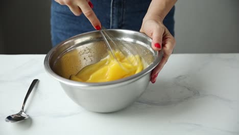 mujer mezclando huevos con un batidor