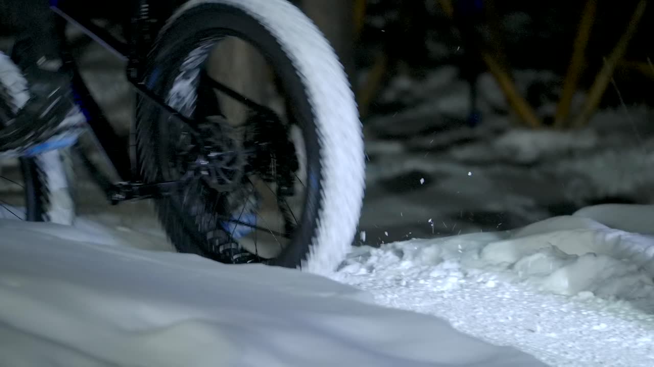 fatbike neumáticos de invierno rodando por la nieve por la noche slomo
