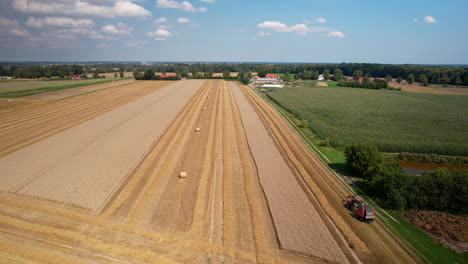 vast agriculture land with harvesting activity by tractor in progress