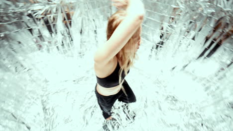 woman energetically dancing contemporary choreography on shiny foil surface