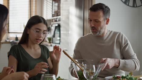 familia caucásica teniendo una conversación vívida durante el desayuno