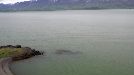 recreational vehicle in iceland with road and water drone video tilting up to mountains