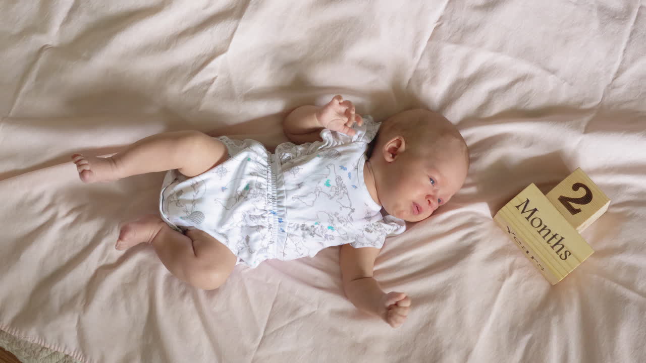 Un bambino di due mesi sdraiato su un letto