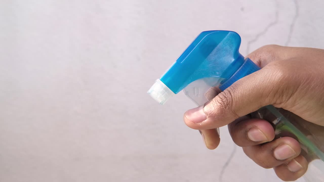 파란 스프레이 병을 들고 있는 손