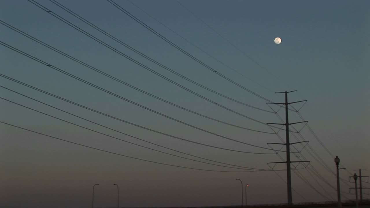 전력선 위에 매달려 있는 보름달을 롱샷