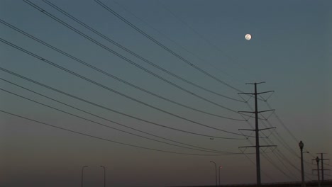longshot the full moon hanging above power lines