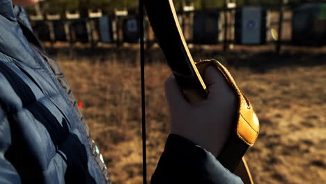 hand of a young man holding a recurve bow