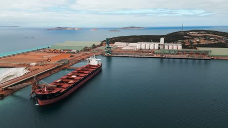 drone-shot-of-cargo-ship-beeing-loaded-in-the-industrial-port-of-Esperance,-Esperance-harbour,-Western-Australia