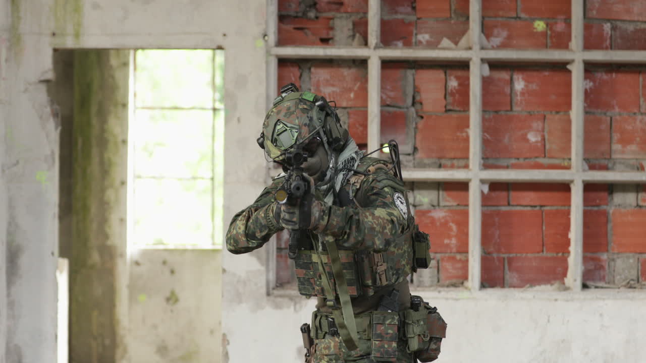 jugador de airsoft camuflado apuntando a un arma de fuego de imitación - toma de cámara lenta media