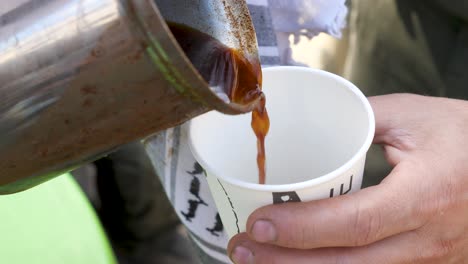 Man-serving-coffee-in-a-cup,-difficult-days-in-Gaza