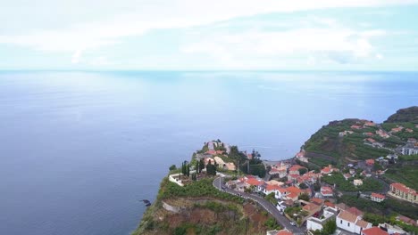 Drohnenaufnahme-über-Dem-Dorf-Ponta-Do-Sol-Mit-Blick-Auf-Die-Küste-Des-Atlantischen-Ozeans