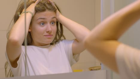 Young-brunette-woman-stressing-and-worrying-in-the-bathroom-mirror,-in-Slow-Motion