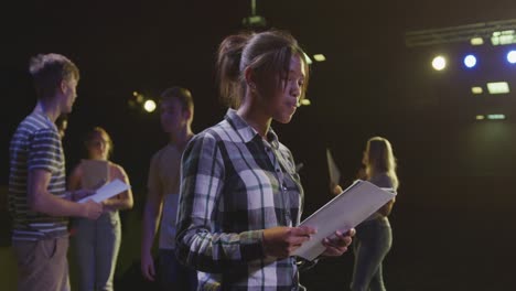 students preparing before a high school performance in an empty school theater