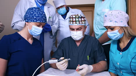 adult male doctor showing the usage of drill machine. attentive students look at teacher's work.