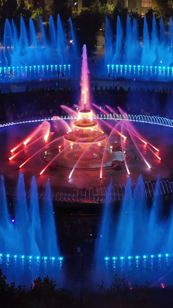 Aerial drone view of the illuminated Bucharest fountains in Romania, at night. Vertical