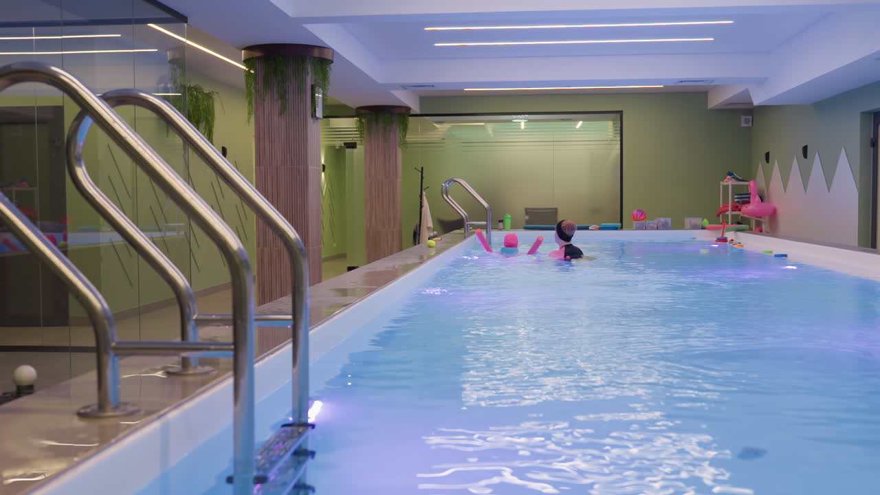 Full capture of clean pool water with two entry ladders, bright reflections on blue tiles, gentle ripples, clear surface detail, resort mood, minimal composition, swim scene under warm daylight