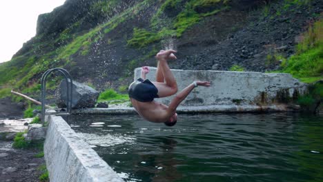 Man-Tumbling-Into-The-Seljavallalaug-Swimming-Pool-In-Southern-Iceland