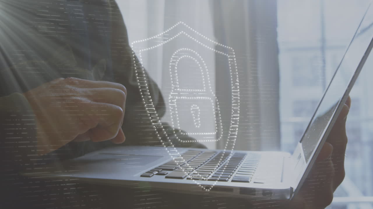 animación de un candado en el escudo sobre la sección media de un hombre caucásico usando una computadora portátil en casa