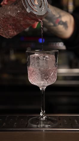 bartender pouring pink cocktail