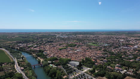 Vista-Aérea-De-La-Ciudad-De-Serignan-Día-Soleado-Occitania-Mar-Mediterráneo-En-Segundo-Plano.