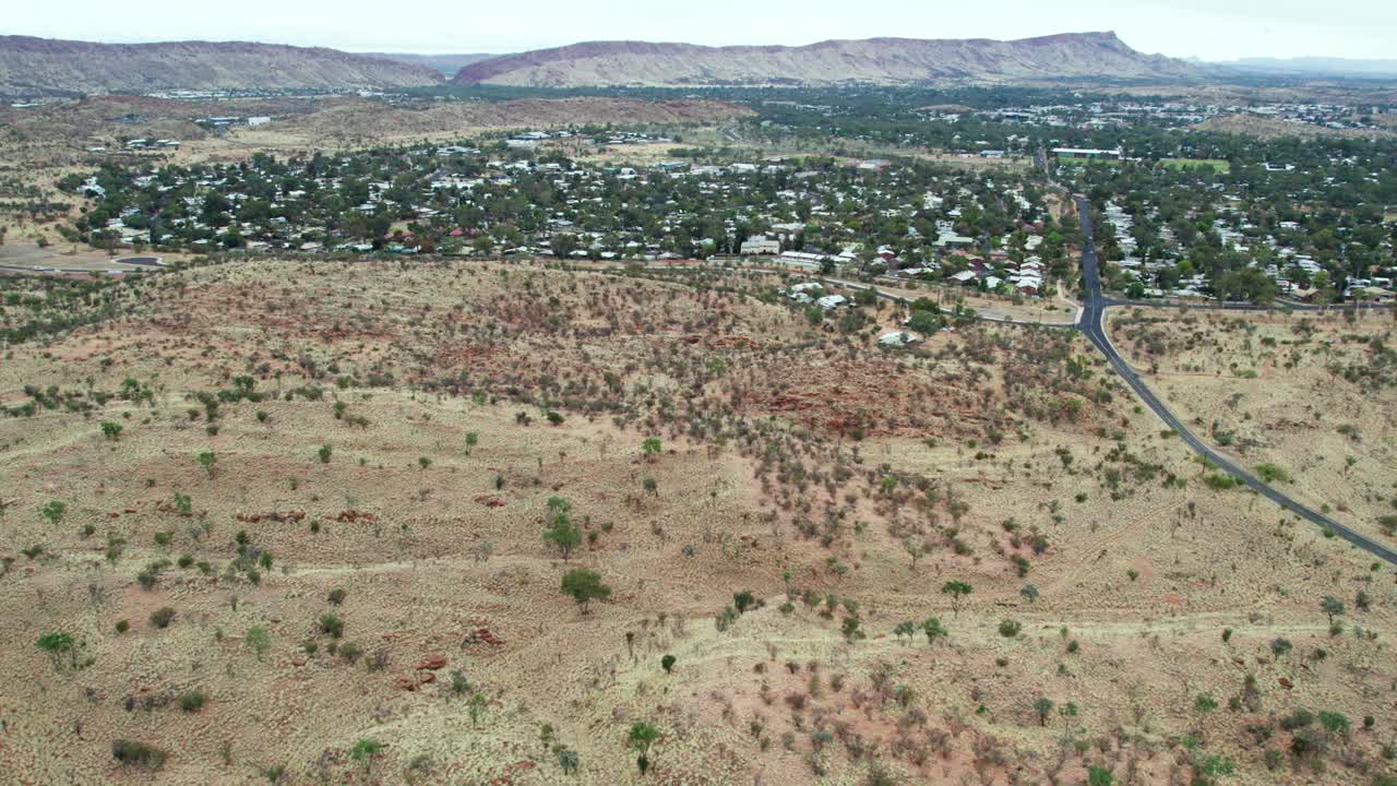 Aerial view looking west along Udoolya Road and Alice Srings, Mparntwe, with the MacDonnell Ranges in the distance. Northern Territory, Australia. August 2022.