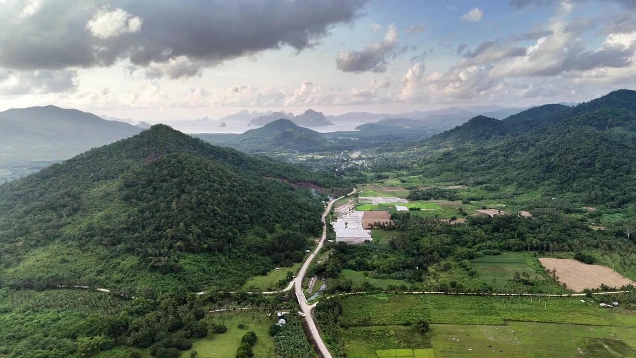 Tomada de drone de alta altitude com panorâmica horizontal sobre El Nido, capturando uma vasta paisagem tropical onde montanhas arborizadas encontram o mar distante.