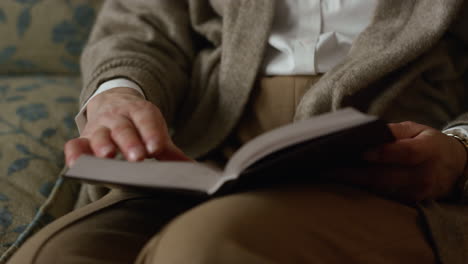 primer plano de una mujer madura con las manos volviendo las páginas de un libro en el interior