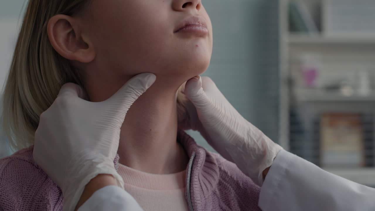 Doctor examining patient's thyroid