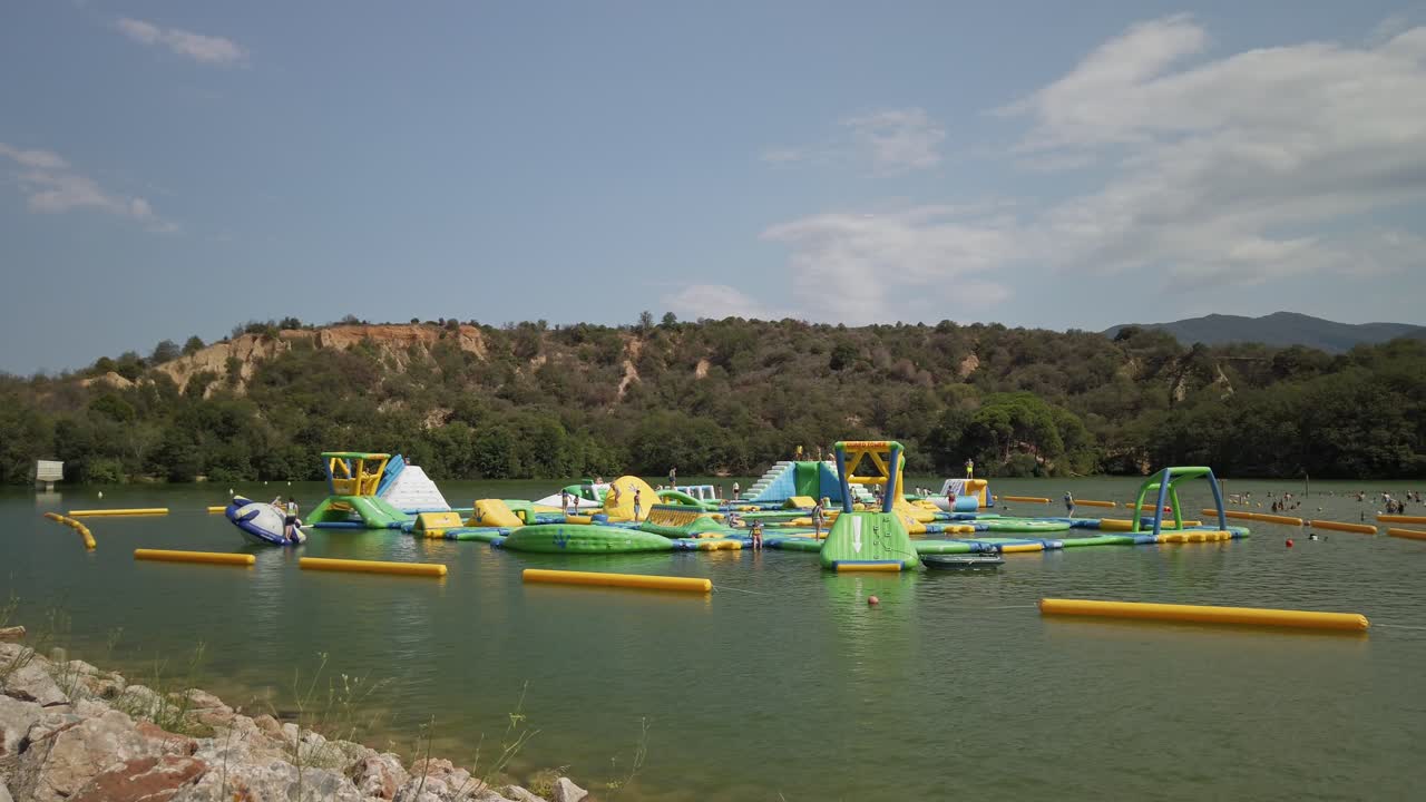 Still images of an inflatable waterpark floating on Lac des Escoumes in Vinça, France