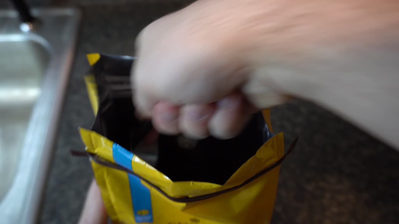 프렌치 프레스에서 커피를 만들기 위해 커피 주머니에서 커피 찌꺼기를 떠내는 것