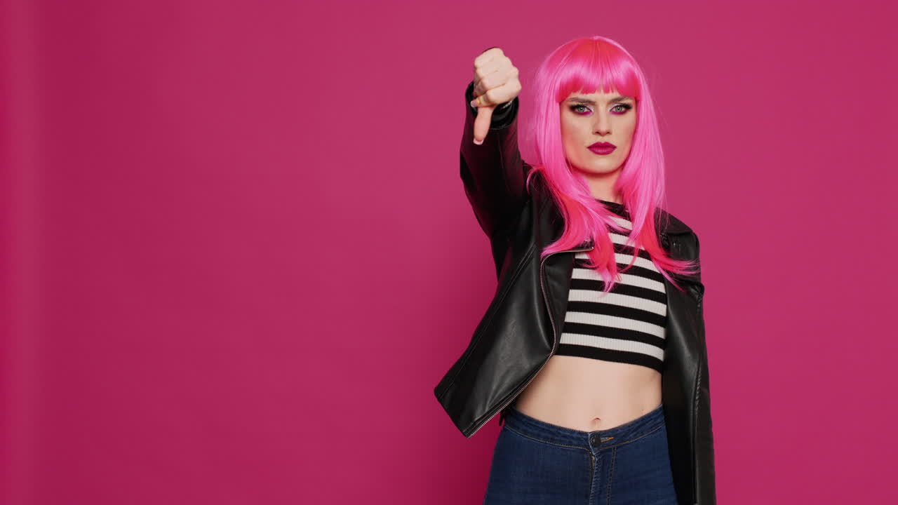 Cool punk woman showing thumbs down sign in studio