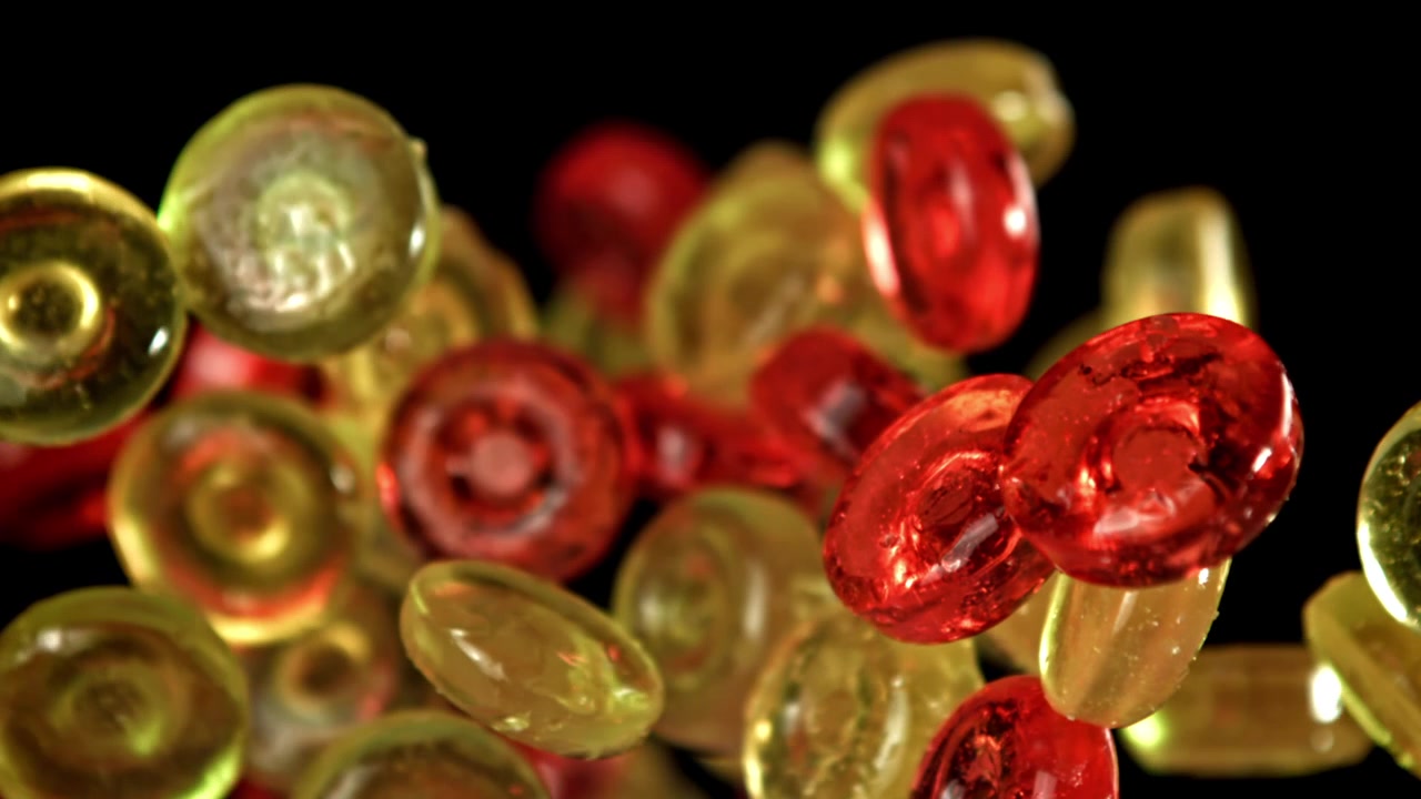 Rote und gelbe Bonbons fallen in Zeitlupe