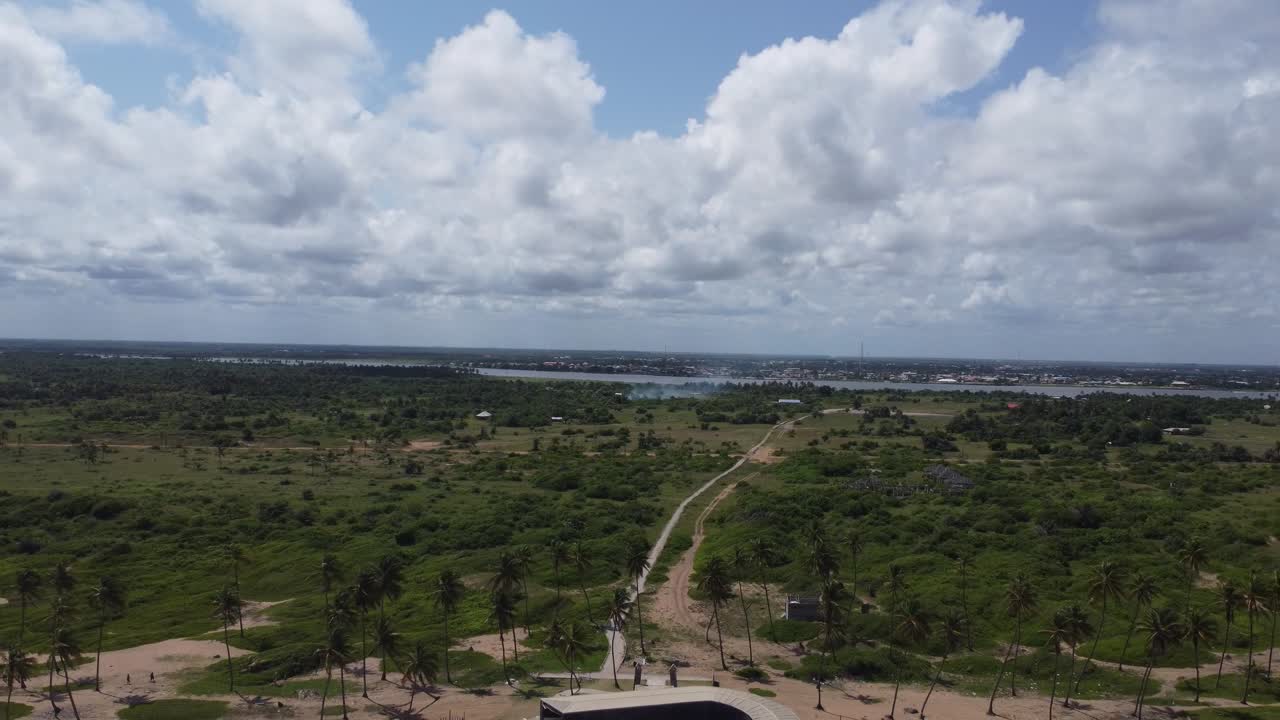 해변 앞의 손바닥은 구름이 많은 날에 바다에 대한 건축 기념비를 통해