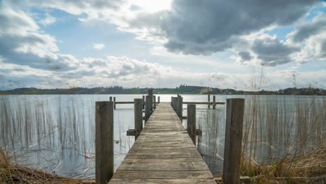 restless clouds move over a lake on a jetty