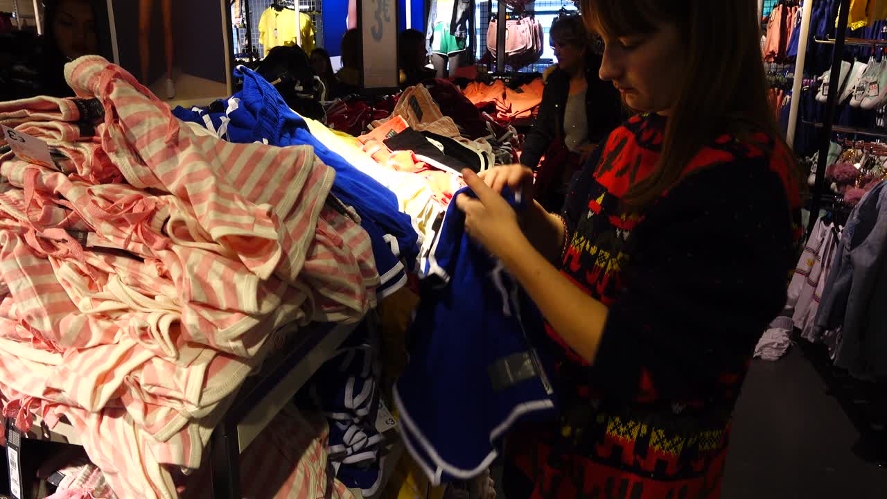 Shopping negli outlet in Europa. La ragazza sceglie i vestiti. Saldi e sconti