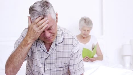 Suffering-senior-man-sitting-on-bed