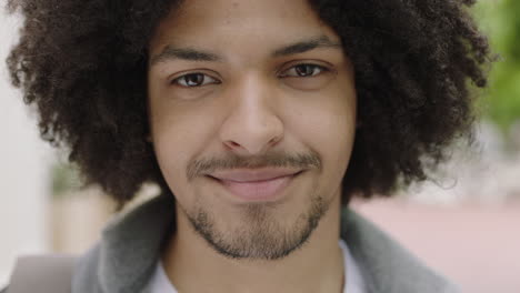 retrato en primer plano de un joven estudiante de raza mixta hombre sonriendo confiado mirando a la cámara disfrutando de un estilo de vida independiente en la ciudad urbana peinado afro de moda