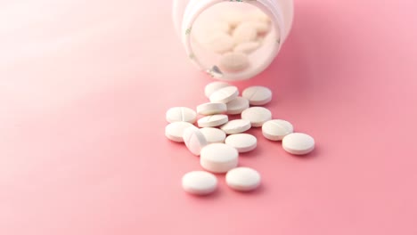 pastillas blancas esparcidas de una botella