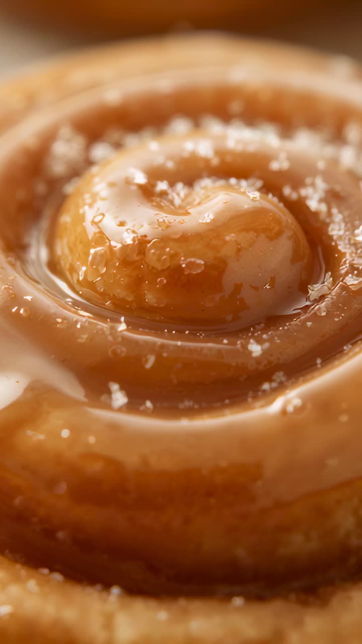 Vertical video: Shift moving camera revealing spiral roll on counter showing glaze shine and salt