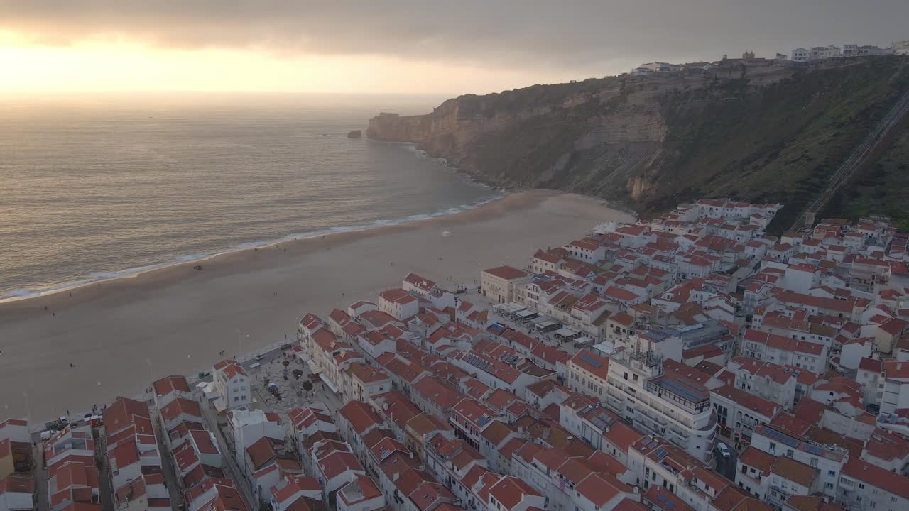 포르투갈 해안에 있는 나자레 마을의 지역 드론 영상이 일몰 골든 아워 4k 동안 촬영되었습니다.