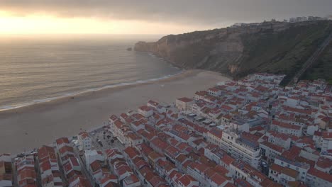 Flächendrohnenaufnahmen-Der-Stadt-Nazare-An-Der-Küste-Portugals,-Gefilmt-Während-Der-Goldenen-Stunde-Des-Sonnenuntergangs-4k