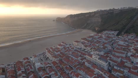 imágenes de drones de la ciudad de nazare en la costa de portugal filmadas durante la hora dorada del atardecer 4k