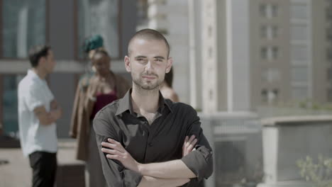 confident employee standing on rooftop and posing for camera