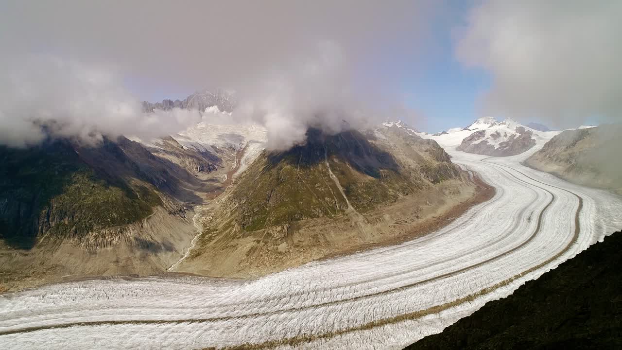 Europe longest glacier winding through steep Swiss mountains beneath cloudy sky