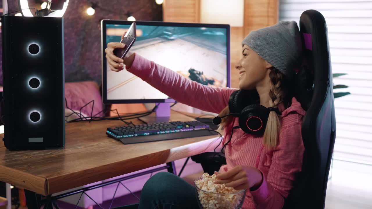 una joven se sienta en su poderosa computadora de juegos y toma una foto selfie en el teléfono