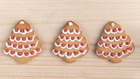 seamless looping stop motion animation with three cookies shaped christmas tree on wooden background