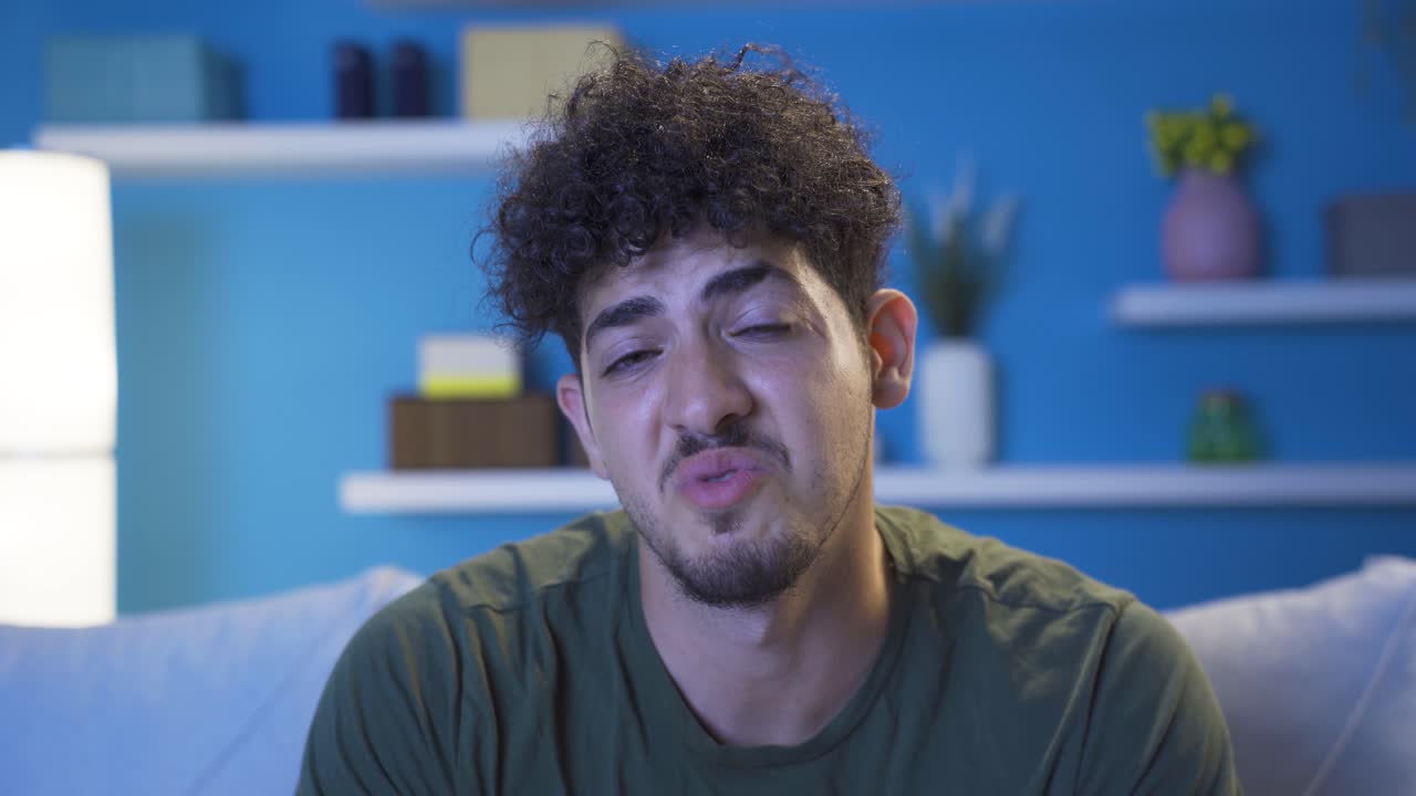 retrato en primer plano de un joven que se siente culpable en casa por la noche.