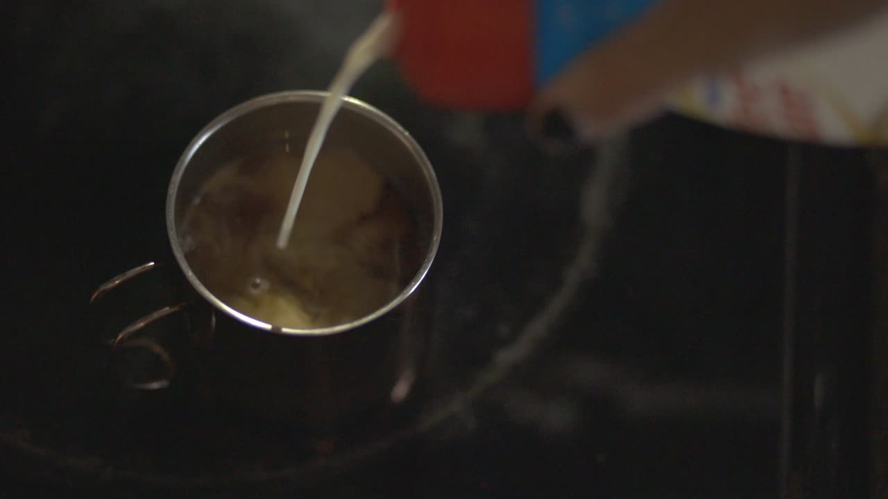 Pouring Milk On A Black Coffee In A Stainless Cup. - Close Up Shot