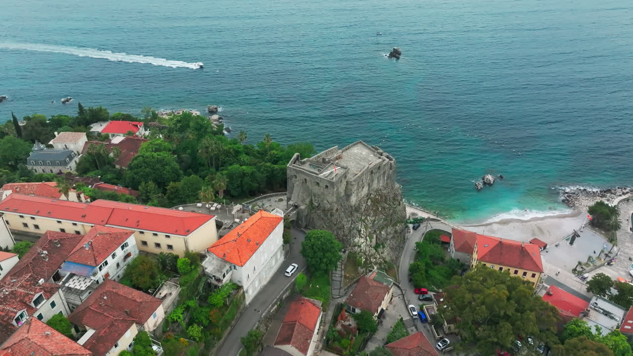드론은 헤르체그 노비의 오래된 해안 요새를 터키즈 파란 바다와 함께 드러니다.
