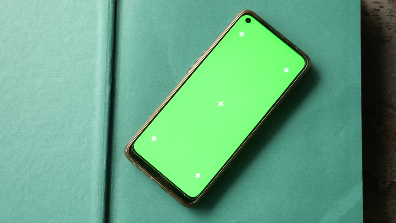teléfono inteligente con pantalla verde en un libro